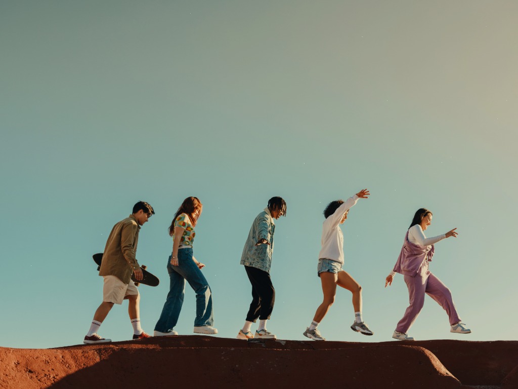 young people walking along a wall