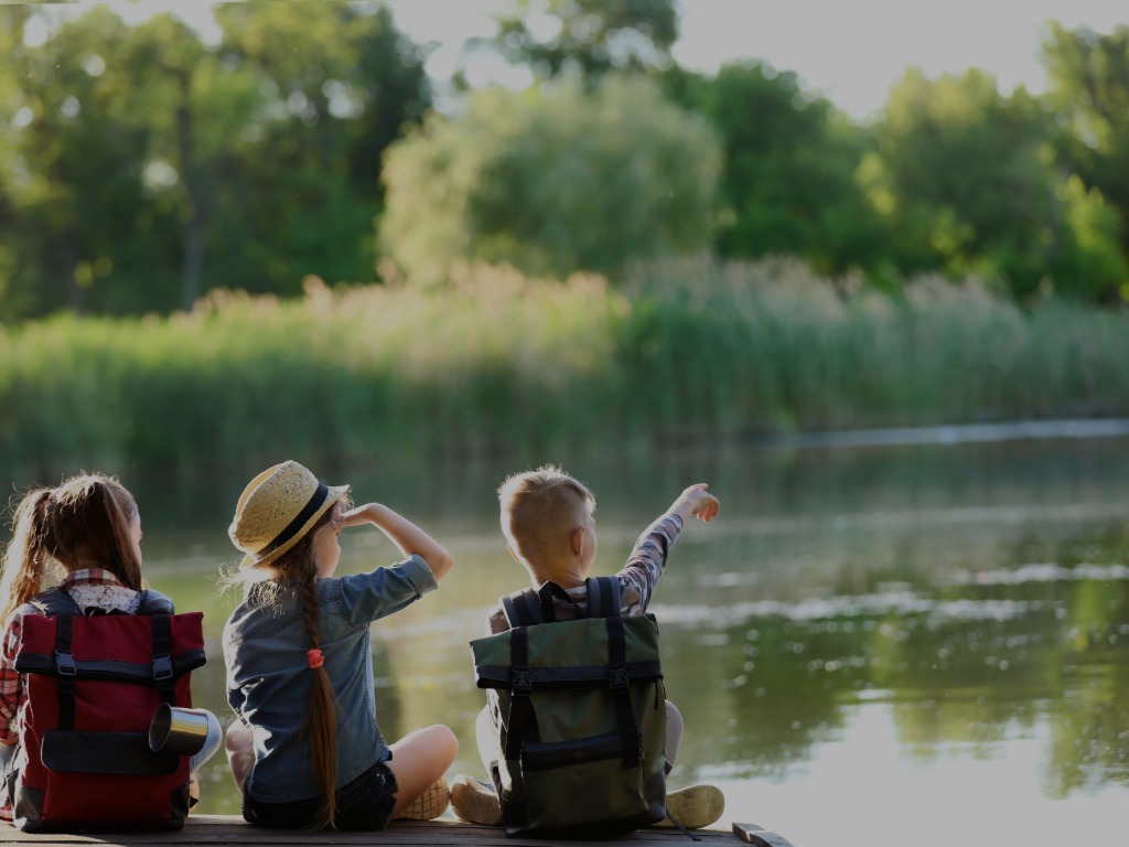 children sitting by a lake