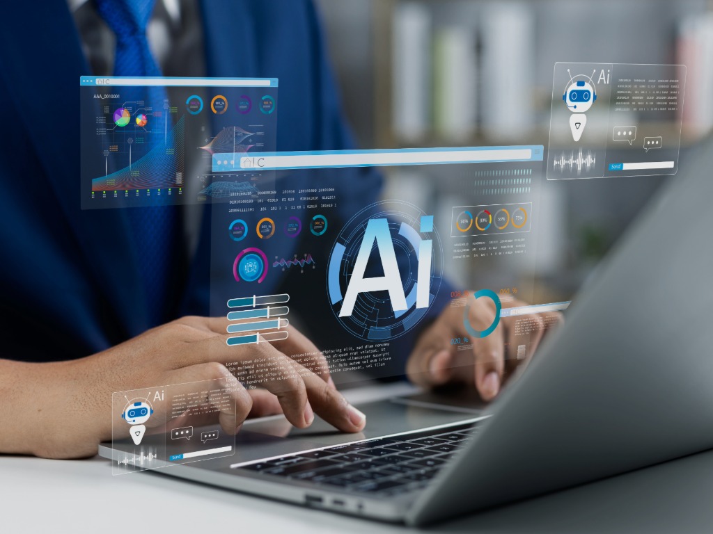 someone typing at a computer and the letters AI are on the screen