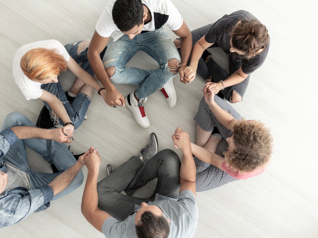 teens sitting in a circle, praying