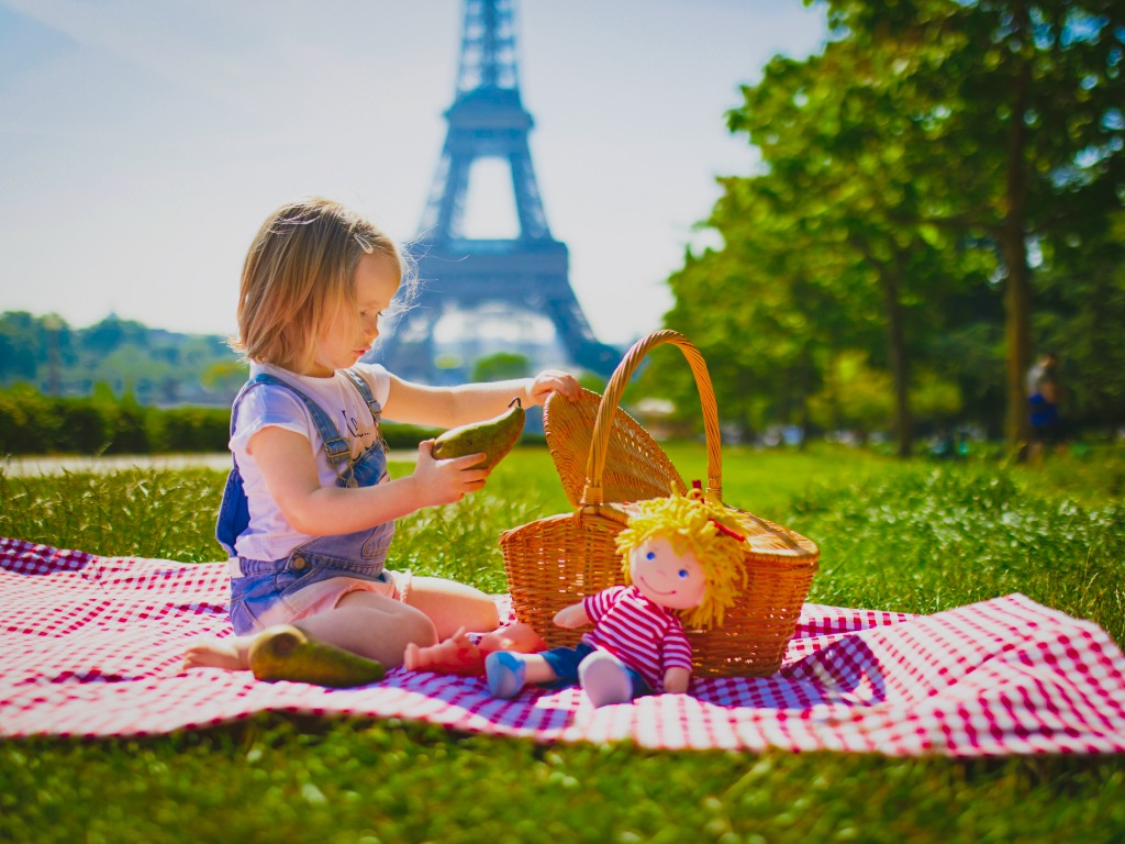 child having a pic-nic in front of the Eiffel Tower, France