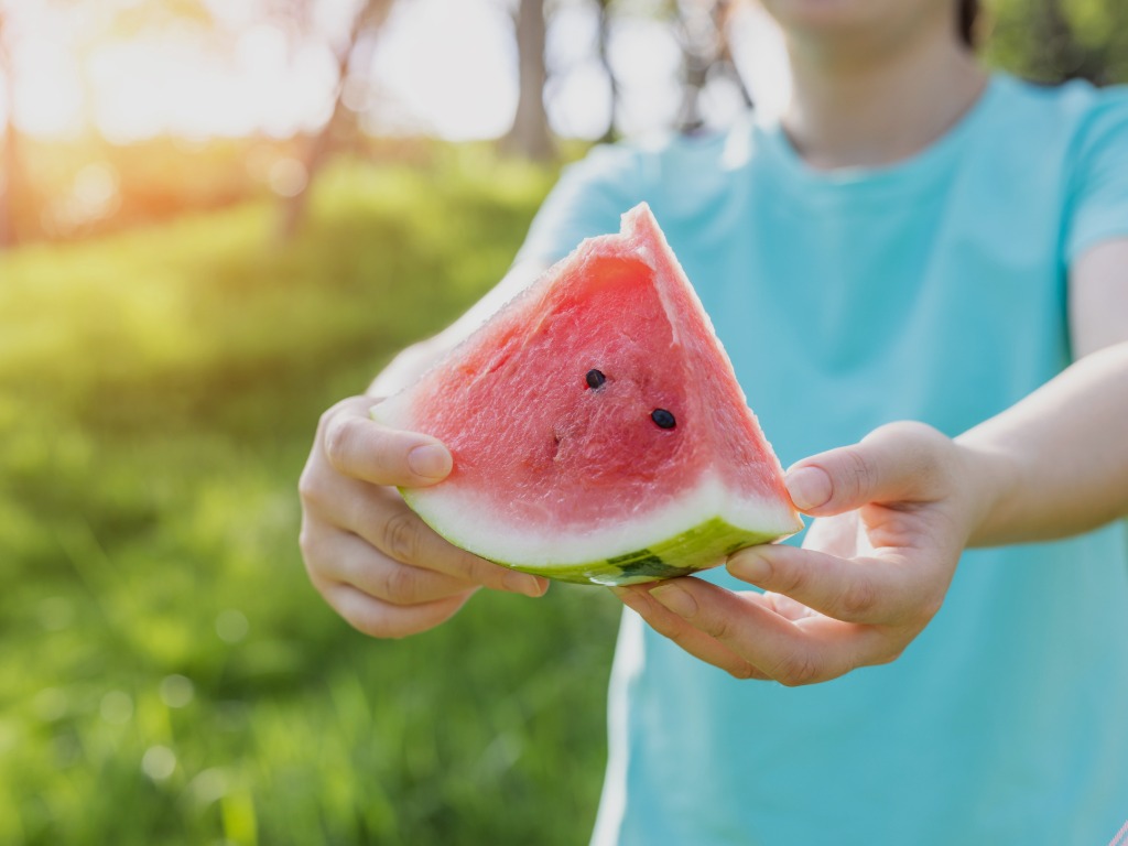 child holding a watermelon